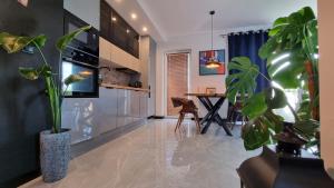 a living room with a table and some plants at Apartament Madlen Art in Olecko