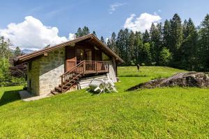 une cabane en rondins avec une terrasse sur un champ verdoyant dans l'établissement Baita Cechin, à Saone