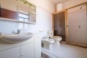 a white bathroom with a sink and a toilet at Casa Stella vista Eolie in San Pier Niceto +14 photos