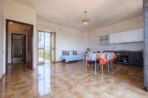 a kitchen and living room with a table and chairs at Casa Stella vista Eolie in San Pier Niceto