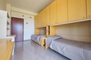 une chambre avec deux lits et une cuisine avec des placards dans l'établissement Casa Stella vista Eolie, à San Pier Niceto