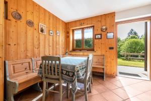 a dining room with wooden walls and a table and chairs at Baita zia Mariota Zeller in Tione di Trento