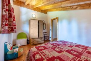 1 dormitorio con cama y techo de madera en Baita zia Mariota Zeller, en Tione di Trento