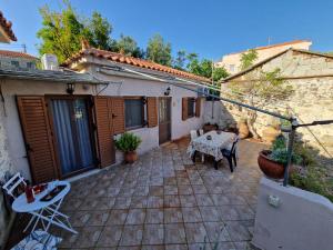 a patio with a table and chairs and a building at Afroditi's 1 in Eresos
