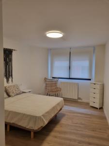 a bedroom with a bed and a chair in it at Apartamentos Encanto Mudéjar in Teruel