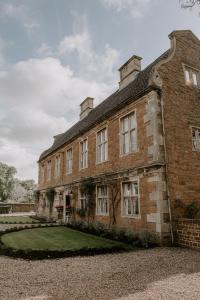 um velho edifício de tijolos com um jardim de relva em Allington Manor em Allington