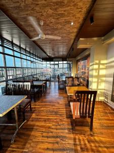 un restaurant avec des tables et des chaises en bois ainsi que des fenêtres dans l'établissement HOTEL ROYAL SUITES +, à Kokkíni Khánion