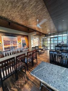 a dining room with wooden tables and chairs and windows at HOTEL ROYAL SUITES + in Ajmer