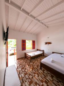 a room with two beds and a tv in it at Hosteria El Paraiso in Jardin