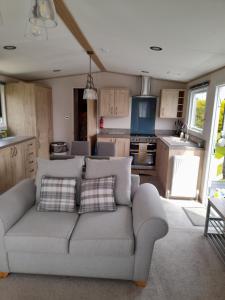 a living room with a couch and a kitchen at Kent Getaways in Westgate on Sea
