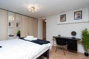 um quarto com uma cama branca e uma secretária em Coastal Modern One Bedroom Apartment Free Parking em Great Yarmouth