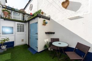 a small patio with a blue door and a table at Coastal Modern One Bedroom Apartment Free Parking in Great Yarmouth