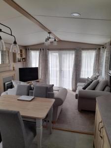 ein Wohnzimmer mit einem Sofa und einem Tisch in der Unterkunft Kent Getaways in Westgate-on-Sea