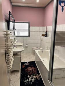 une salle de bain avec un lavabo, une baignoire et des toilettes dans l'établissement FeWo mit 3 SZ, direkte Innenstadtlage, Südterrasse, Parkplatz auf dem eigenem Privatgrundstück, 2x E-Bike und E-Autoladesäule inklusive, Konzertkirche, Schauspielhaus, FH, Jahnsportforum sowie der Tollensesee sind fußläufig in ein paar Minuten erreichbar, à Neubrandenbourg