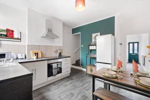 a kitchen with a table and a refrigerator at Elegant Scandi Gem of Nottingham - Sleeps 10 in Nottingham