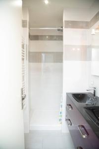 y baño con ducha y lavamanos. en Exceptionnel Loft de 250 m2, en Deuil-la-Barre