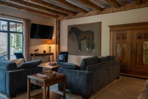 a living room with two couches and a horse painting on the wall at Ferienwohnung in den Dorfwiesen in Gersfeld