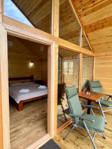 a room with a bed and a desk and chairs at Cabana Bahna 2 in Orşova