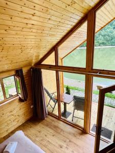 une chambre avec une grande fenêtre dans une cabane en bois dans l'établissement Cabana Bahna 2, à Orşova