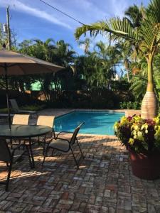 a patio with a table and chairs next to a pool at Case de León from the 1920's is a piece of Floridas relaxing history in West Palm Beach