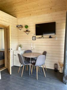 a dining room with a table and chairs and a tv at Cozyhouse in Slavske