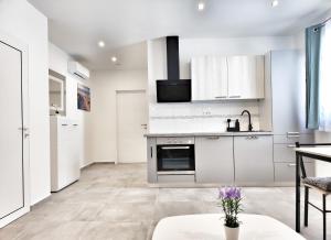 kuchnia z białymi szafkami i piekarnikiem w obiekcie Apartments Tina Stinjan w Puli