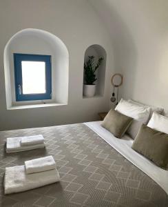 a bedroom with a large bed with two towels on it at Arco Bianco Suites in Akrotiri