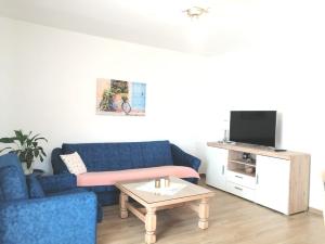 a living room with a blue couch and a table at Lovely Sea View House in Malinska Island Krk in Malinska