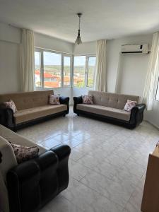 a living room with two couches and a large window at Beyaz Saray Apart Otel in Ayvalık