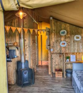 een kamer met een houtkachel in een hut bij Under the Oak Glamping in Caerphilly