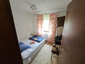 um pequeno quarto com uma cama e uma janela em Apartman Slapovi em Krupa na Vrbasu
