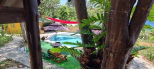 a view of a swimming pool with a umbrella and chairs at Wild Hippie Chang 