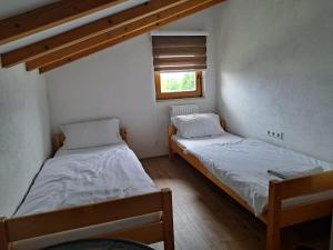 2 camas en una habitación pequeña con ventana en Rooms Delux Sarajevo en Sarajevo