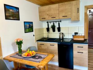 Una cocina con una mesa con un bol de fruta encima. en Mały Bystry Domek, en Kościelisko 20 fotos más