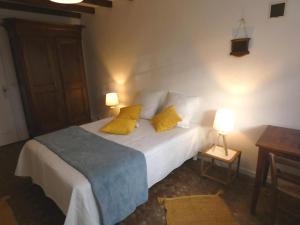 ein Schlafzimmer mit einem Bett mit zwei gelben Kissen in der Unterkunft Gite la touque in Bascons
