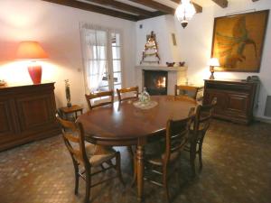 ein Esszimmer mit einem Tisch, Stühlen und einem Kamin in der Unterkunft Gite la touque in Bascons