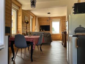 cocina y sala de estar con mesa y sillas en L'apparté de G, Gîte 3 étoiles de montagne cosy, en Gérardmer