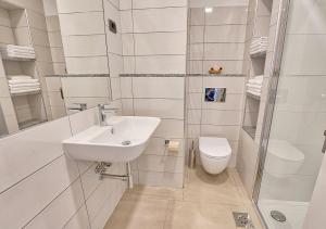 a white bathroom with a sink and a toilet at Apartments Bagar in Portorož