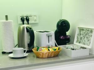 a counter with a coffee maker and a basket of food at SLAVNA - Luxe & Wine by the Fortress in Belgrade