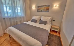 a large bed in a room with a large window at Apartments Bagar in Portorož