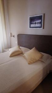 Una cama con dos almohadas encima. en Hotel Miramare, en Lavagna