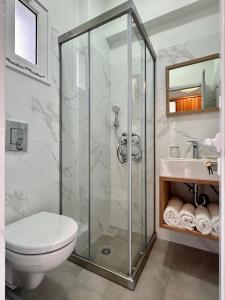 een badkamer met een douche, een toilet en een wastafel bij Lia Studios in Loutra Edipsou