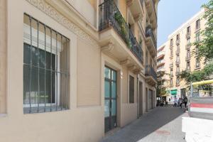 ein Gebäude auf einer Straße mit Leuten, die die Straße hinuntergehen in der Unterkunft Sagrada Familia Apartment in Barcelona