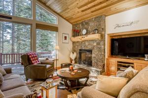a living room with a stone fireplace and a tv at Tahoe Discovery in South Lake Tahoe