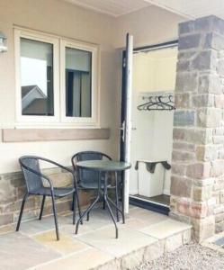 a patio with a table and chairs next to a window at The Wee Stay - Room Only - Rural 1 Bed Guest Suite in Middleton Fossoway