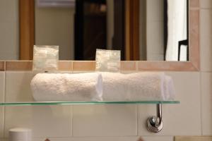 a towel on a glass counter in front of a mirror at Hotel Primavera in Peschiera del Garda +60 photos