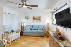 a living room with a couch and a flat screen tv at Skipjack Resort & Marina #404 in Marathon