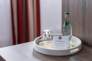 una botella de champán en un recipiente metálico sobre una mesa en Hotel Grosse Klus, en Bückeburg