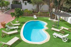 a pool with chaise lounge chairs and a group of lawn chairs at Rancho Grande in Marbella