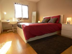 een slaapkamer met een bed met rode lakens en een raam bij La maison d'audignon in Audignon